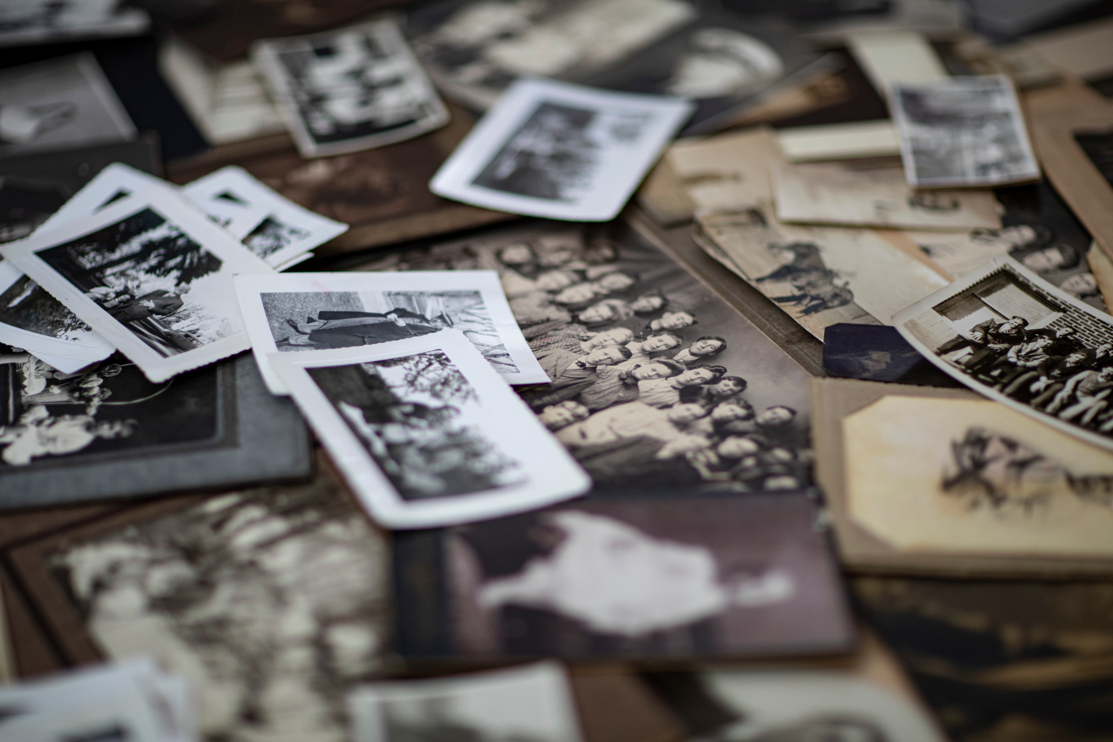 Old black and white family photographs scattered on a surface