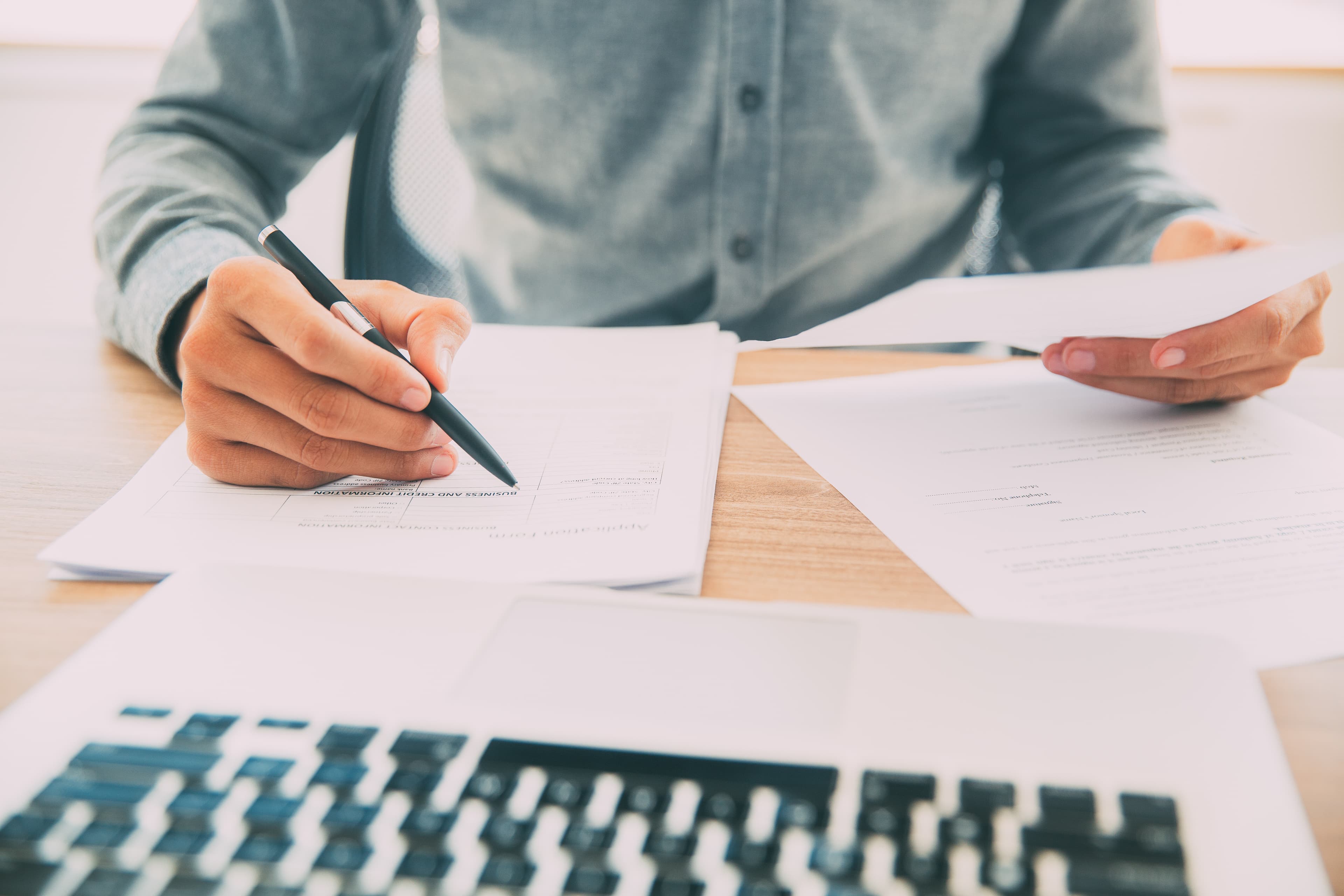 Man at a desk sorting through paperwork and documents