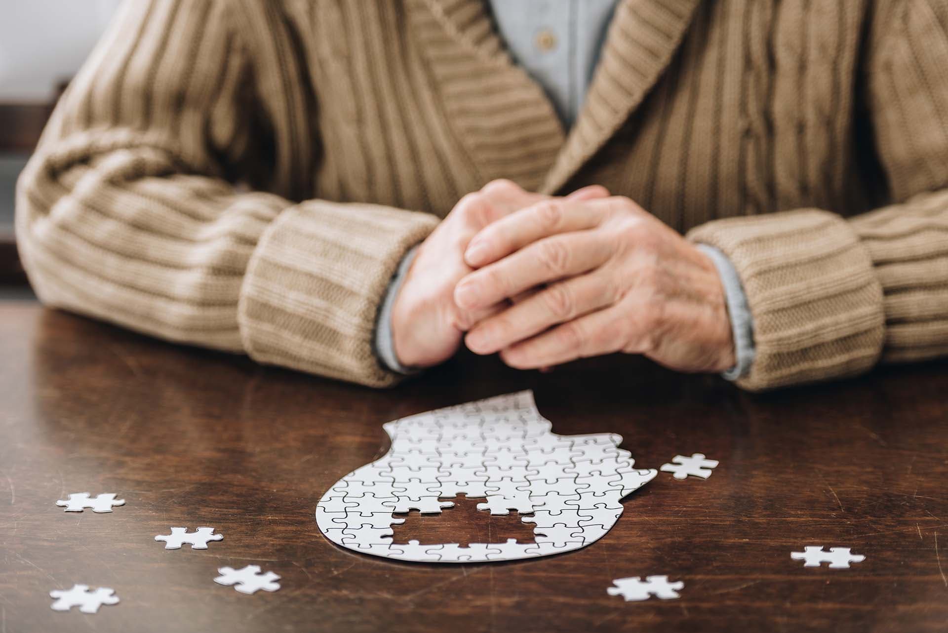 Elderly person's clasped hands at a table
