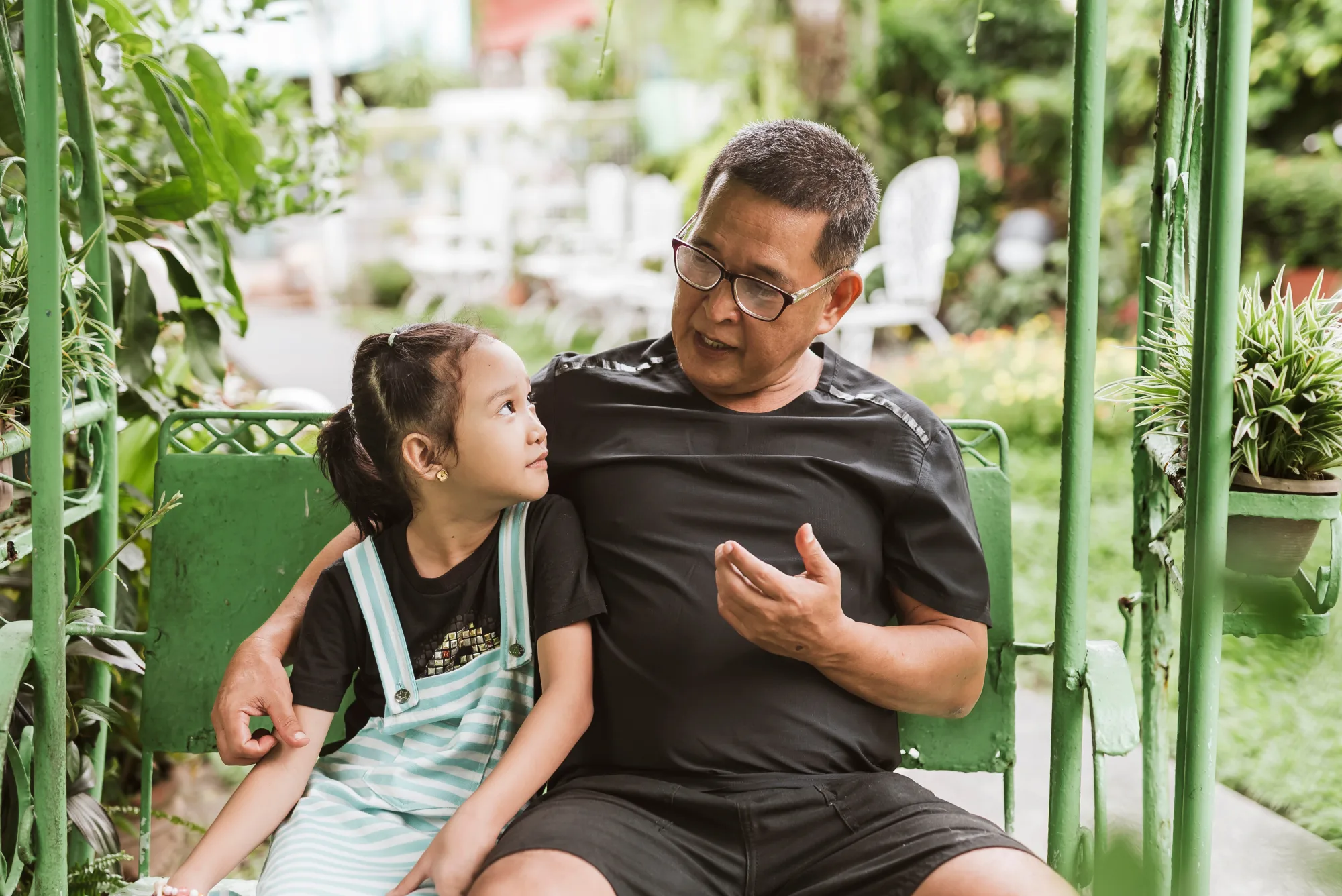 Filipino grandfather talking with his granddaughter
